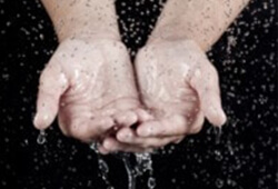 אדם משלב ידיים בעת נזילת מים שאותה על ידי חברת תרמוסטט